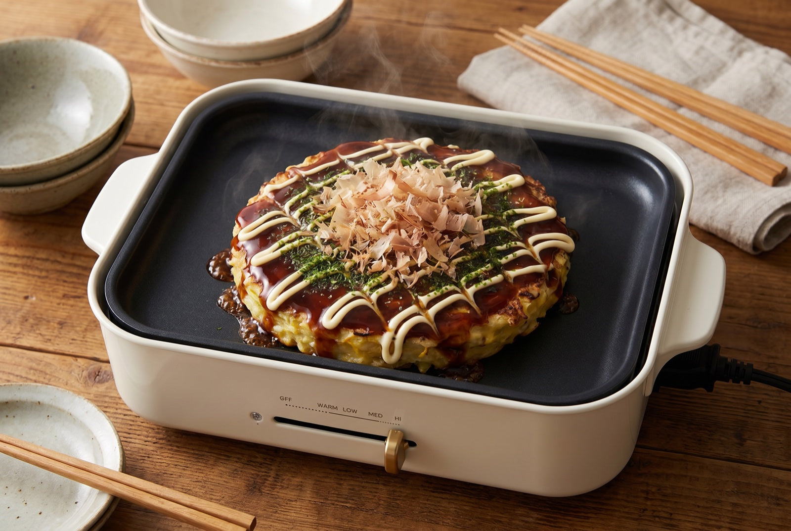 Classic okonomiyaki with sauce, mayo and bonito on a BRUNO hot plate